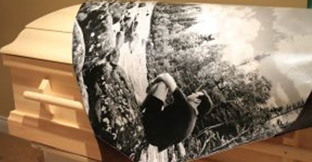 A casket with a blanket draped over it.