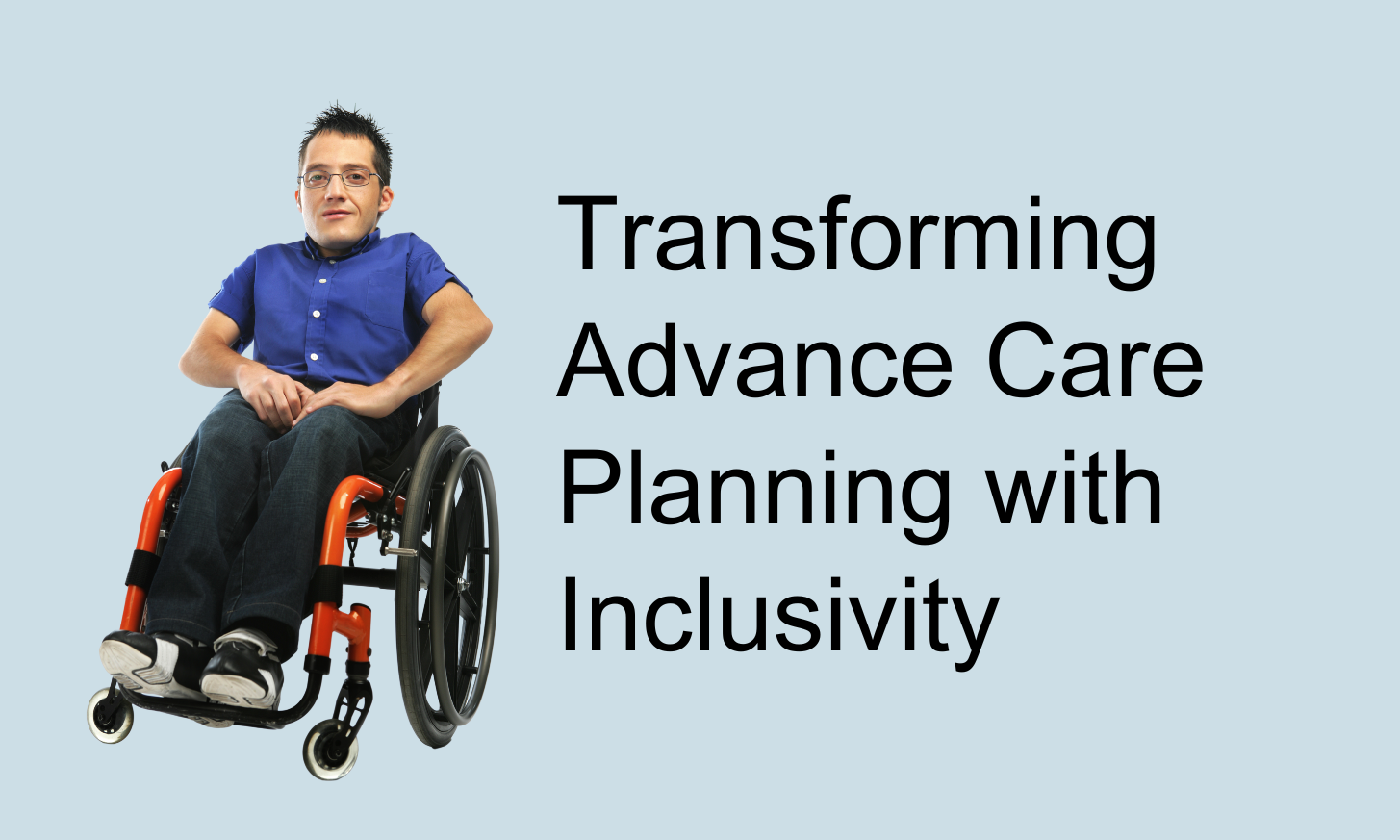 A man with spiky black hair and glasses sitting in a wheelchair.